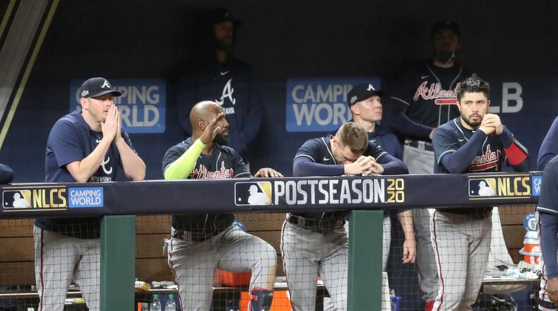 Atlanta Braves players, from left, Tyler Matzek, Marcell Ozuna, Freddie Freeman and Travis d'Arnaud watch from the dugout against the Los Angeles Dodgers during the ninth inning in Game 7 of the National League Championship Series on Sunday, Oct. 18, 2020 at Globe Life Field in Arlington, Texas. (Curtis Compton/Atlanta Journal-Constitution/TNS)