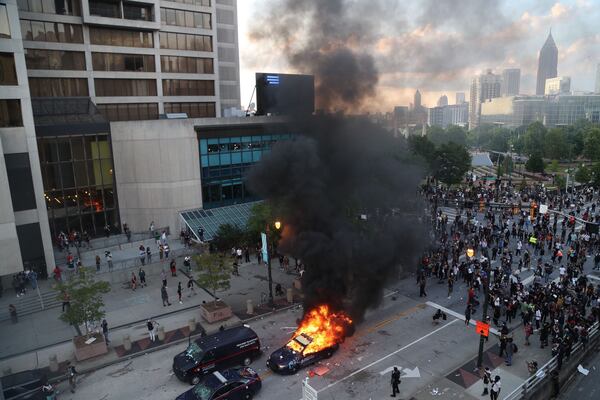 A group of demonstrators set fire to a police car in downtown Atlanta. (AJC 2020)