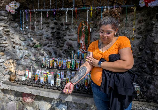 Roxanne Castillo of Albuquerque proudly displays her Virgen the Guadalupe tattoo after praying at an alter near El Santuario De Chimayo in Northern New Mexico on Good Friday, April 18, 2025. Chimayo, N.M. (AP Photo/Roberto E. Rosales)