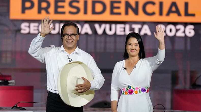 Presidential candidate Keiko Fujimori of the Popular Force party and her rival Roberto Sanchez of Together for Peru party wave during a presidential debate, in Lima, Peru, Sunday, May 31, 2026. (AP Photo/Martin Mejia)