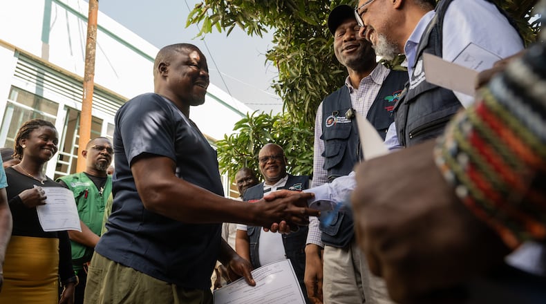 Director General of the World Health Organisation (WHO), Tedros Adhanom Ghebreyesus, right, shakes hands with Ezo Etienne, a health worker who recovered from Ebola in Bunia, Congo, Sunday, May 31, 2026. (AP Photo/Moses Sawasawa)