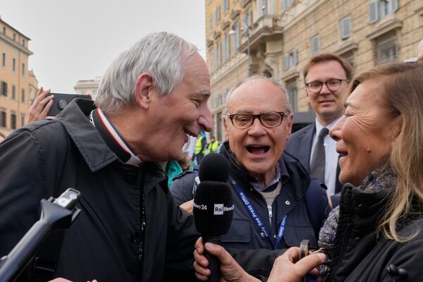Cardinal Matteo Zuppi, left, is approached by reporters as he arrives for a college of cardinals' meeting, at the Vatican, Monday, April 28, 2025. (AP Photo/Gregorio Borgia)