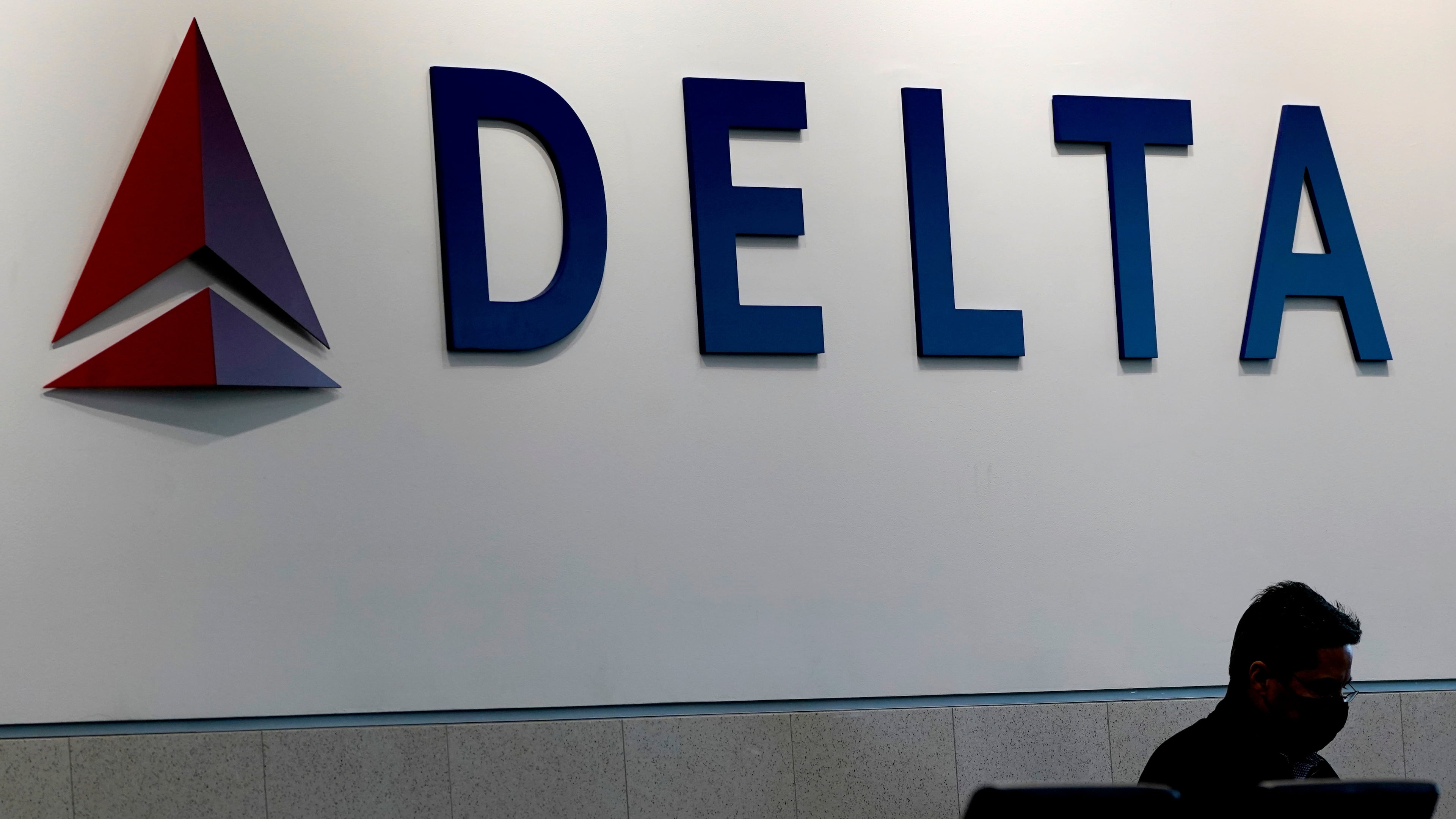 FILE - A man waits for a Delta Airlines flight at Hartsfield-Jackson International Airport in Atlanta on Jan. 7, 2022. (AP Photo/Charlie Riedel, File)