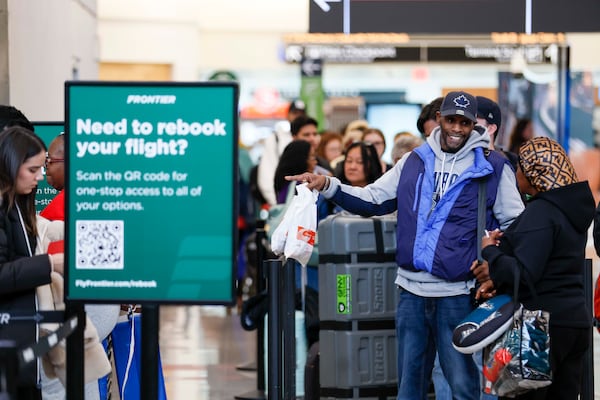 Frontier Airlines travelers lined up to rebook flights at Hartsfield-Jackson Atlanta International Airport on Sunday. (Miguel Martinez/AJC)