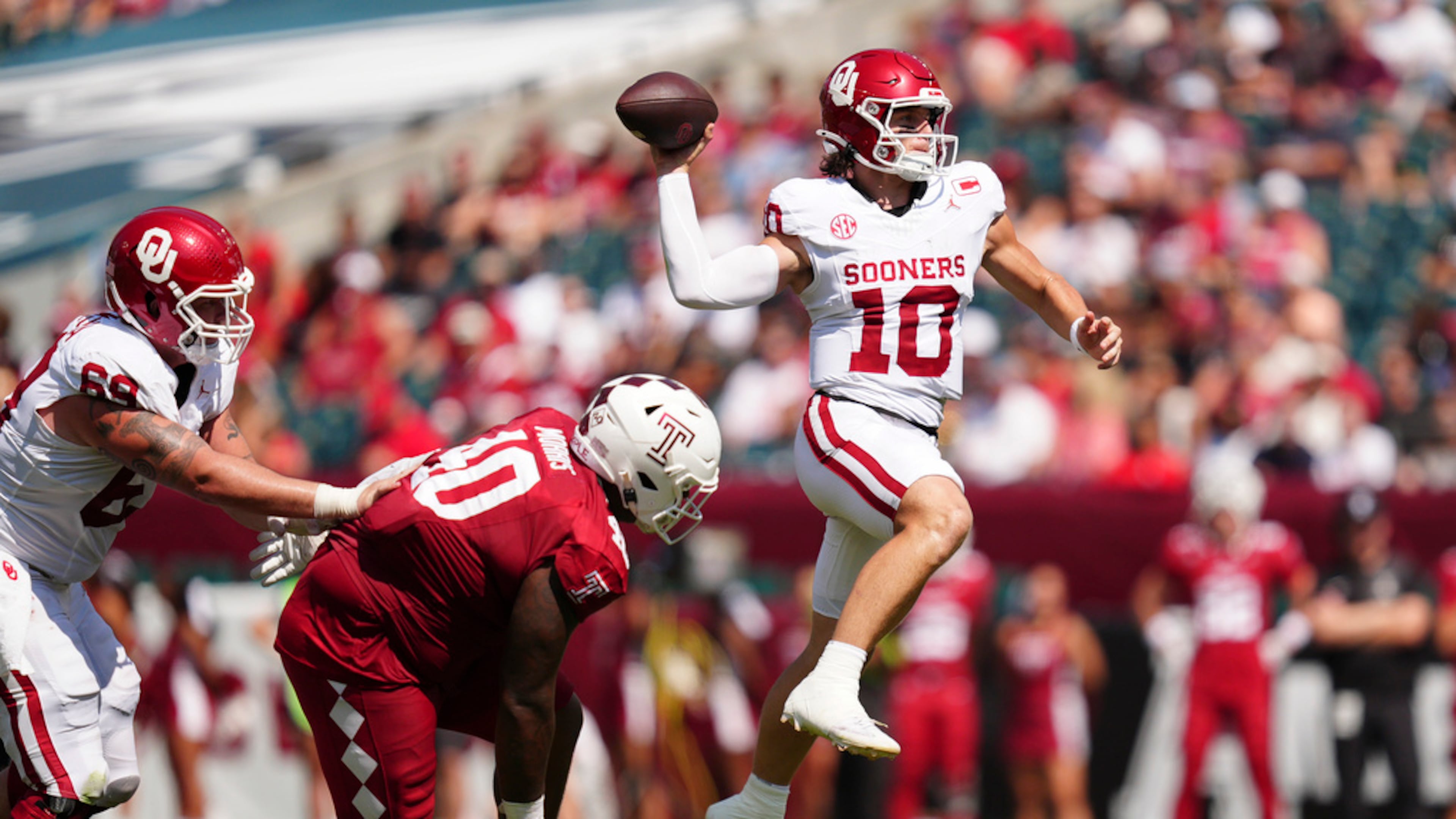 Oklahoma quarterback John Mateer (center) leaps as he throws the ball during the first half against Temple on Saturday, Sept. 13, 2025, in Philadelphia. The Heisman Trophy favorite threw for 282 yards and a touchdown and had a 51-yard rushing touchdown as well. (Derik Hamilton/AP)