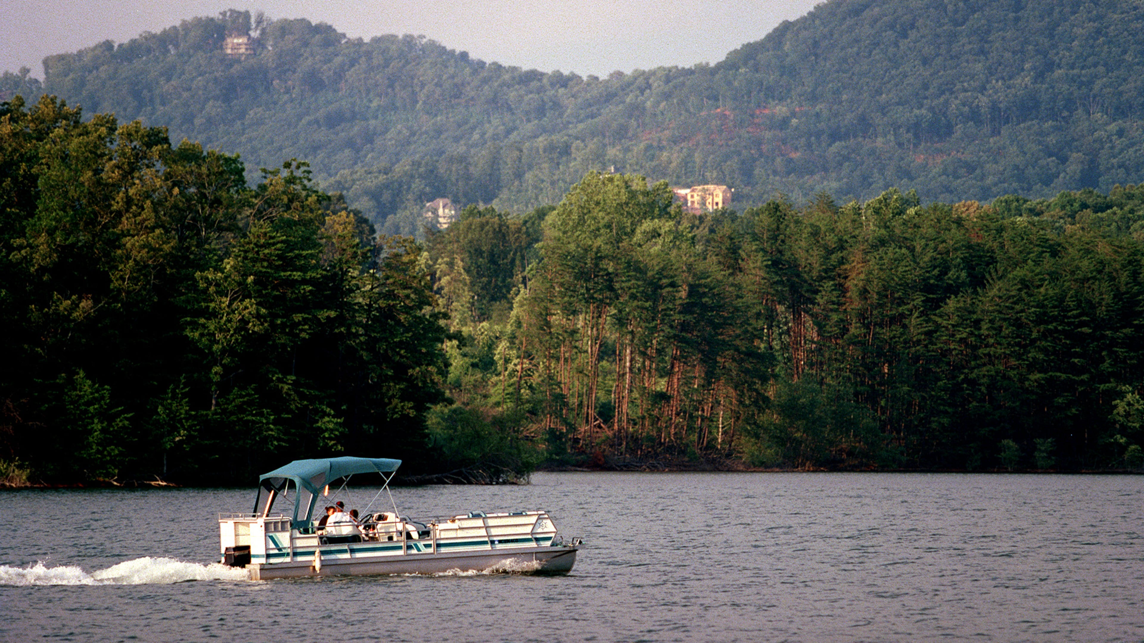 A pontoon boat motors around Lake Chatuge in Georgia with mountain vistas in the background. (Phil Skinner/AJC file)