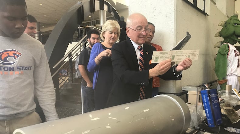Clayton State University President Thomas "Tim" Hynes shows some items put in a time capsule left on the campus in 1994. The time capsule was opened on Sept. 19, 2019 as part of the college's 25th anniversary. ERIC STIRGUS / ESTIRGUS@AJC.COM