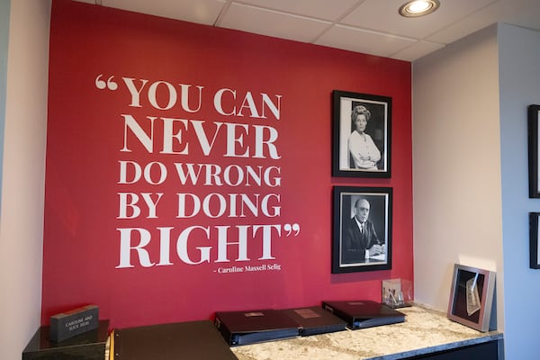 A quote reads, “You can never do wrong by doing right,” with images of Steve Selig’s parents in a conference room at Selig Enterprises, Friday, Dec. 19, 2025, in Atlanta. Selig is retiring after four decades as head of his real estate firm. He’s among Atlanta’s most influential developers and is passing the reins to his daughter and nephew as co-CEOs. (Jason Getz/AJC)