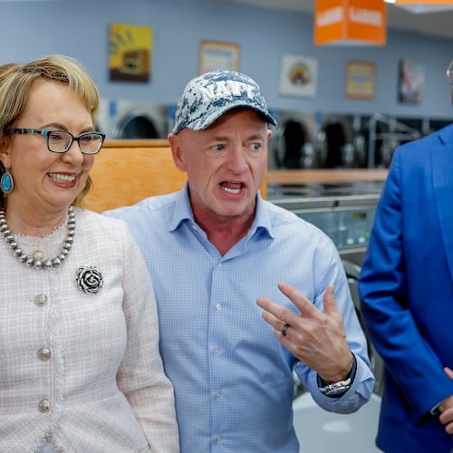 Former Arizona U.S. Rep. Gabby Giffords (left) and her husband, U.S. Sen. Mark Kelly (center), meet with Democratic lieutenant governor nominee Josh McLaurin and others during a campaign stop at the Laundry Lounge in Sandy Springs on Wednesday, Aug. 19, 2026. (Erik S. Lesser for the AJC)