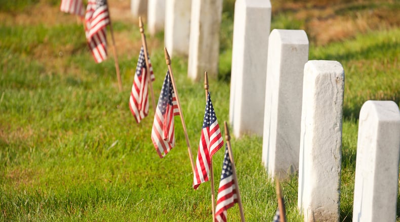 American flags are placed near gravestones at Arlington National Cemetery in Virginia