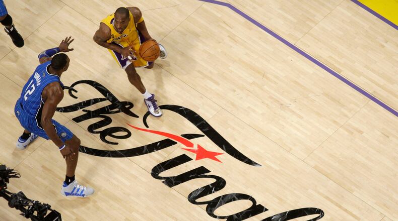 FILE - Los Angeles Lakers guard Kobe Bryant dribbles as Orlando Magic center Dwight Howard defends during the second half of Game 1 of the NBA basketball finals June 4, 2009, in Los Angeles. (AP Photo/Mark J. Terrill, File)