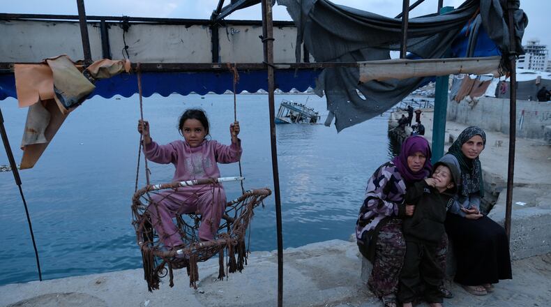 A Palestinian girl sits on a swing in the port of Gaza City on the Mediterranean Sea, Saturday, Dec. 6, 2025. (AP Photo/Jehad Alshrafi)