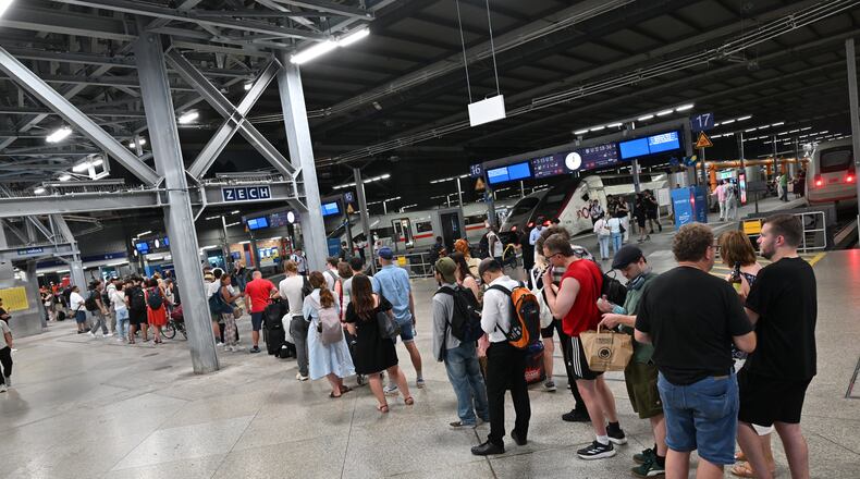 Passengers stand in line at the DB information desk at the Munich train station, Tuesday, June 23, 2026. (Peter Kneffel/dpa via AP)