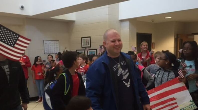 Air Force veteran Paul Davidson walks with his daughter, Kelli, 6, a first-grader at Lovin Elementary School, on a Veterans Day parade held at the school on Friday, Nov. 11, 2016. ERIC STIRGUS/estirgus@ajc.com