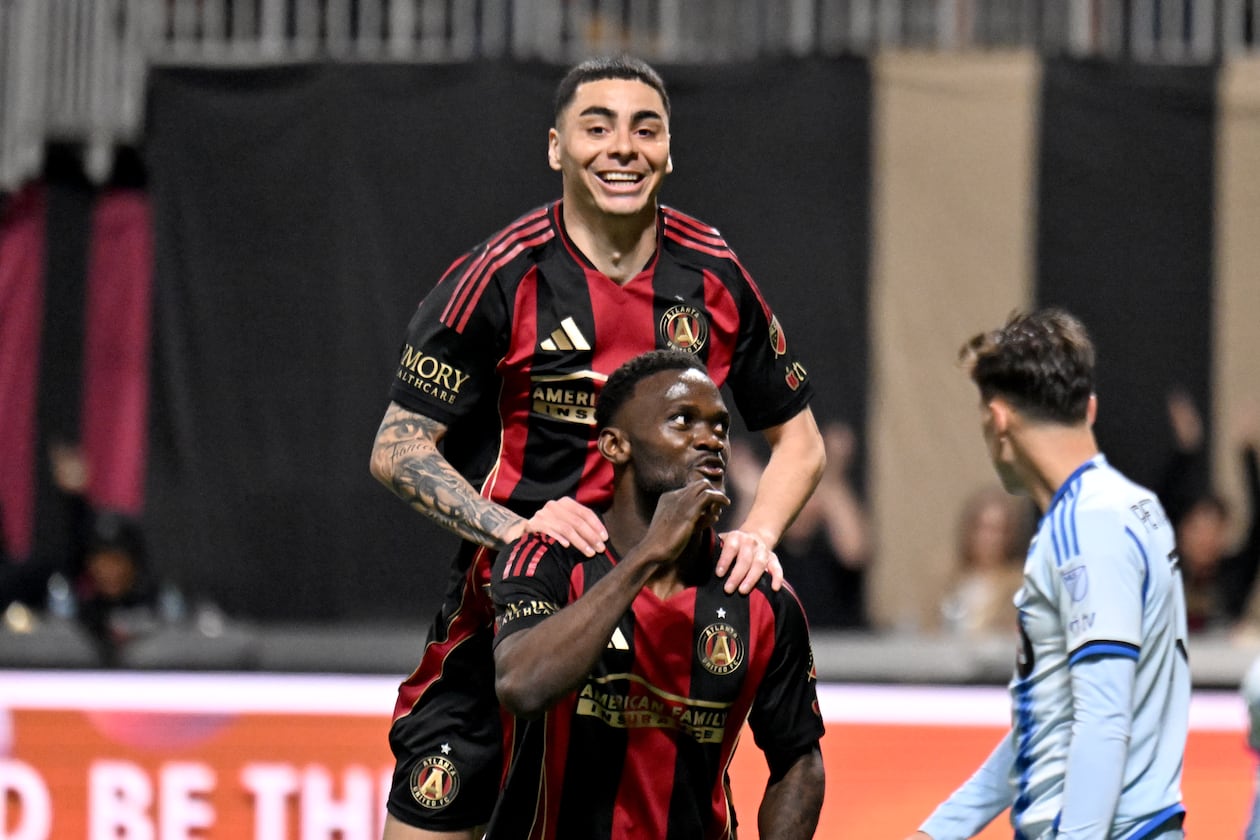 Atlanta United midfielder Miguel Almiron (behind) celebrates forward Emmanuel Latte Lath after Latte Lath scores during the second half of Atlanta United’s MLS season opener at Mercedes-Benz Stadium in Atlanta. Atlanta United won 3-2 over CF Montreal. (Hyosub Shin/AJC 2025)