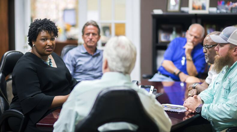 Georgia Democratic gubernatorial candidate Stacey Abrams, left, meets with a group of employees at the Coastal Solar office in Hinesville. Abrams has scored a fundraising success with more than 31,000 donations of less than $100, account for about $1.3 million. But much of that haul has come from outside the state, giving Republicans an issue in the race. (AP Photo/Stephen B. Morton)