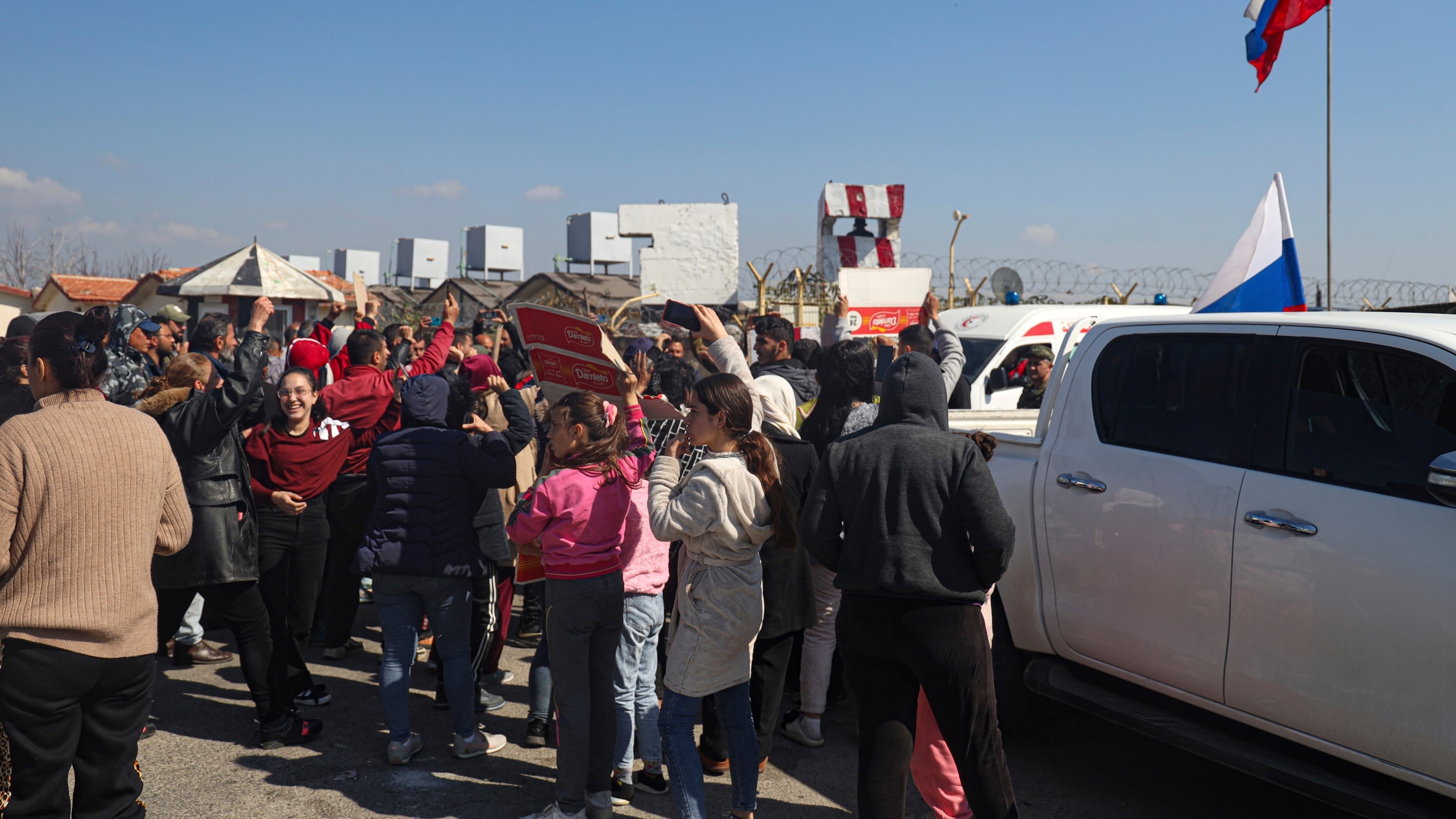 FILE - Members of the Alawite minority gather outside the Russian air base in Hmeimim, near Latakia in Syria's coastal region, March 11, 2025, as they seek refuge there after recent violence and retaliatory killings in the area. (AP Photo/Omar Albam, File)