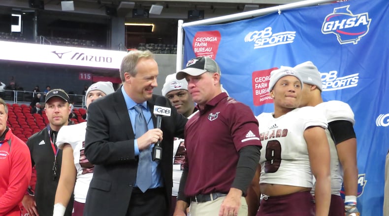 Heard County Braves coach Tim Barron and his players stand at the podium for the Class AA state championship trophy presentation following their 27-6 win over the Rockmart Yellow Jackets on Wednesday, Dec. 12, 2018 at Mercedes-Benz Stadium. (Adam Krohn/special)