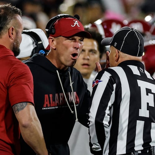 Alabama head coach Kalen Deboer, center, speaks with an official during the first half in the first round of an NCAA College Football Playoff against Oklahoma, Friday, Dec. 19, 2025, in Norman, Okla. (AP Photo/Alonzo Adams)