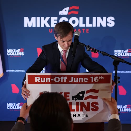 Brandon Phillips, consultant for Republican U.S. Senate candidate Mike Collins, places a sign during Collins’ primary election watch party at The Carmichael House in Jackson on May 19, 2026. (Arvin Temkar/AJC)