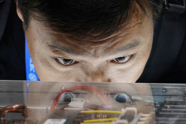 A visitor looks at Quantum-X800 infiniBand networking platform at the Nvidia booth during the 3rd China International Supply Chain Expo at the China International Exhibition Center, in Beijing, China, Friday, July 18, 2025. (AP Photo/Mahesh Kumar A.)