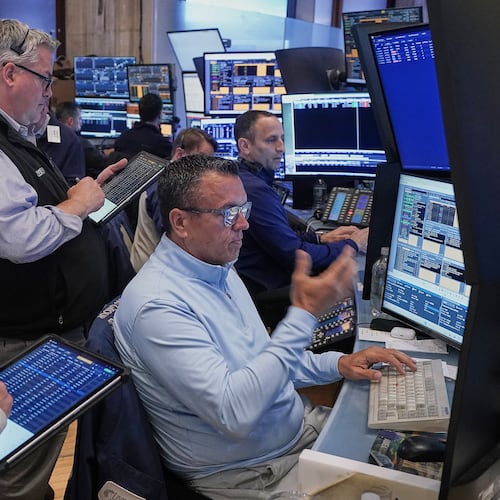 Robert Finnerty, Jr., foreground right, works with colleagues on the floor of the New York Stock Exchange, Thursday, May 7, 2026. (AP Photo/Richard Drew)