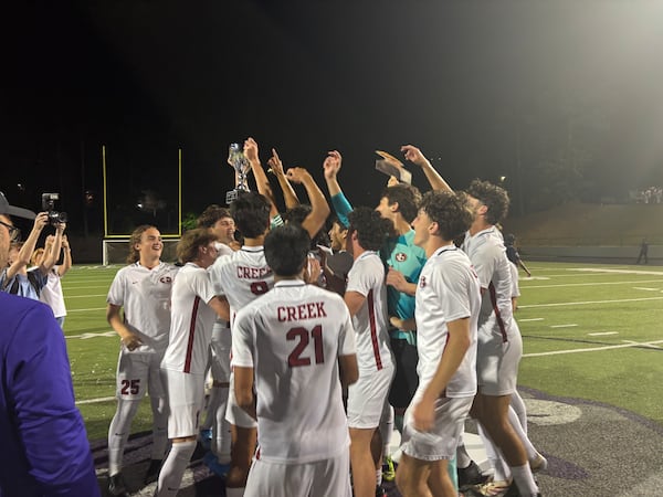 Johns Creek celebrates after defeating River Ridge 2-0 on May 13, 2026, to win the Class 5A soccer championship. It was the school’s first title. (Stan Awtrey for the AJC)