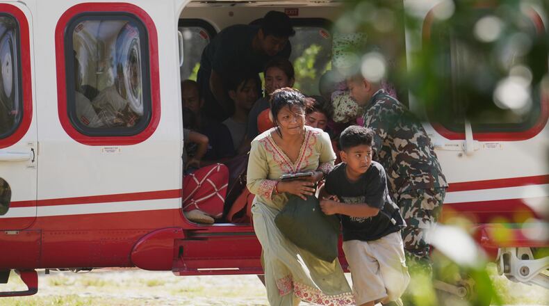 Army soldiers help a family disembark from a helicopter after they are rescued from an area affected by flash flooding in Nepal's Nuwakot district, Friday, Aug. 28, 2026. (AP Photo/Rajesh Kumar Singh)