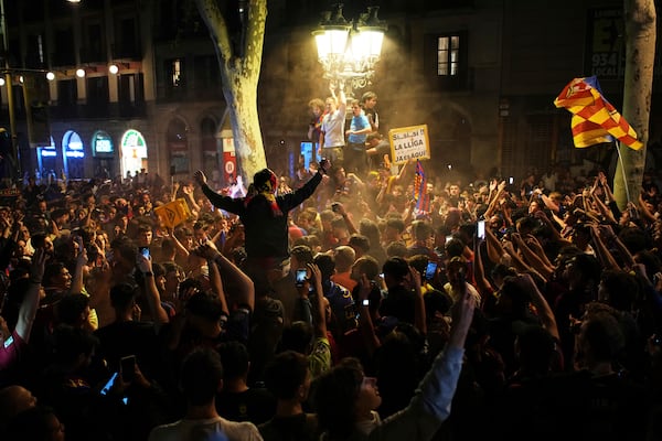 Barcelona fans celebrate in the street after their team won the Spanish La Liga soccer championship in Barcelona, Spain, Thursday, May 15, 2025. (AP Photo/Emilio Morenatti)