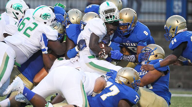 Buford's Anthony Grant (center) is tackled by McEachern defenders during the first half at Walter H. Cantrell Stadium in Powder Springs, Friday, Sept. 4, 2015.