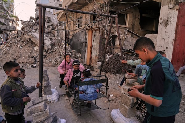 Palestinian children play on swings amid the rubble during Eid al-Fitr in Jabaliya, Gaza Strip, on Monday, March 31, 2025. (AP Photo/Jehad Alshrafi)