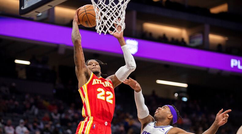 Atlanta Hawks forward Cam Reddish (22) drives to the basket past Sacramento Kings guard Buddy Hield (24) in the first quarter of an NBA basketball game in Sacramento, Calif., Wednesday, Jan. 5, 2022. (AP Photo/José Luis Villegas)