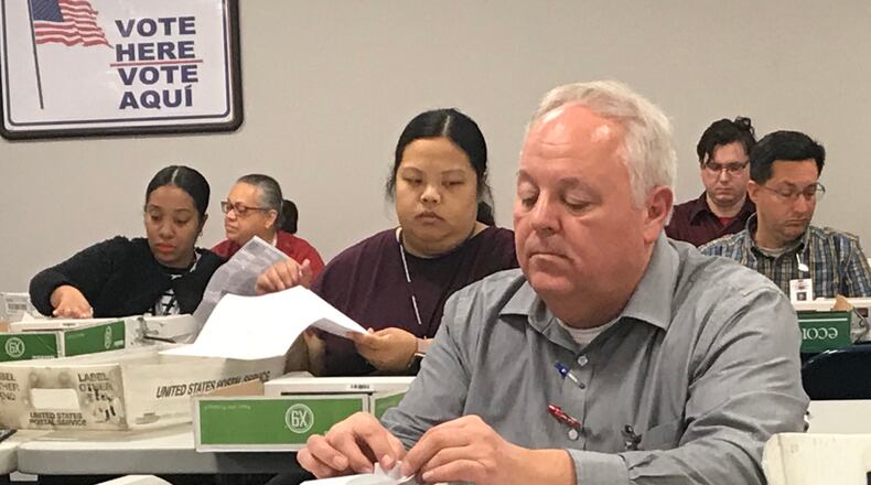 Gwinnett County elections staff process absentee ballots prior to Thursday night's elections board meeting. TYLER ESTEP / TYLER.ESTEP@AJC.COM