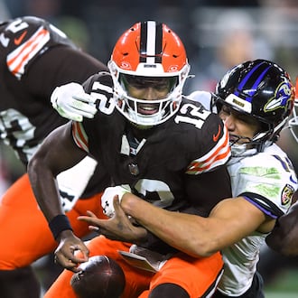 Cleveland Browns quarterback Shedeur Sanders (12) is sacked by Baltimore Ravens safety Kyle Hamilton (14) in the second half of an NFL football game in Cleveland, Sunday, Nov. 16, 2025. (AP Photo/David Richard)