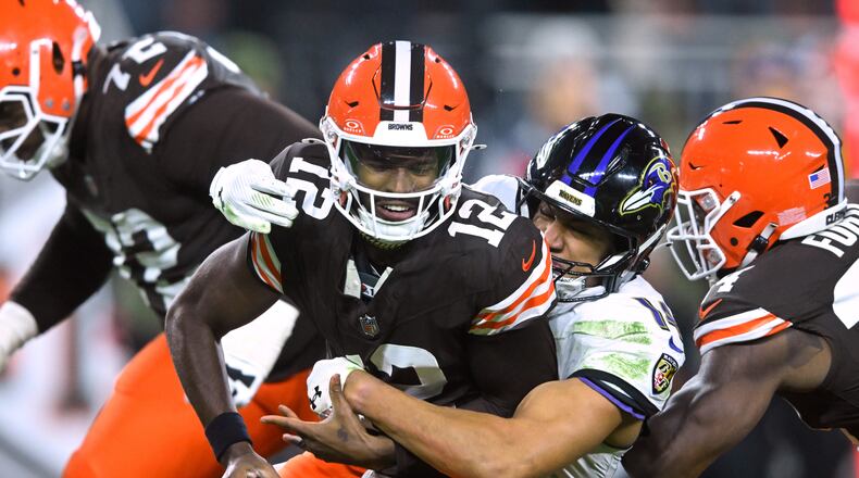 Cleveland Browns quarterback Shedeur Sanders (12) is sacked by Baltimore Ravens safety Kyle Hamilton (14) in the second half of an NFL football game in Cleveland, Sunday, Nov. 16, 2025. (AP Photo/David Richard)