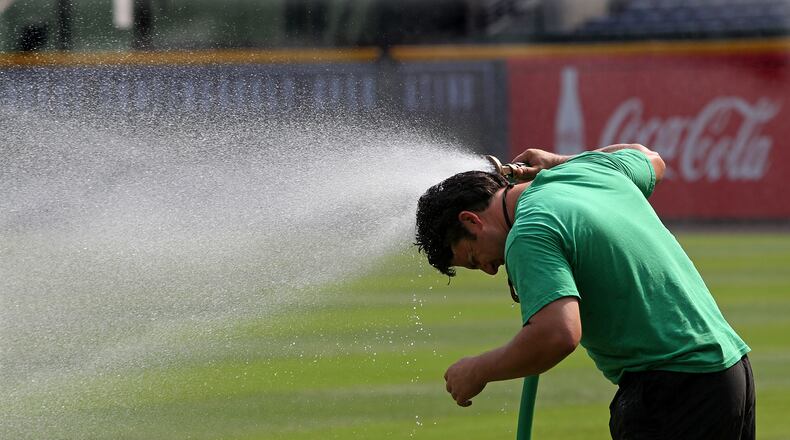 With temperatures expected to top another record today John Frazier, 34, a member of the Atlanta Braves ground crew, turns the hose on himself to cool down while preparing the field for the game against the Washington Nationals at Turner Field on Sunday, July 1, 2012.