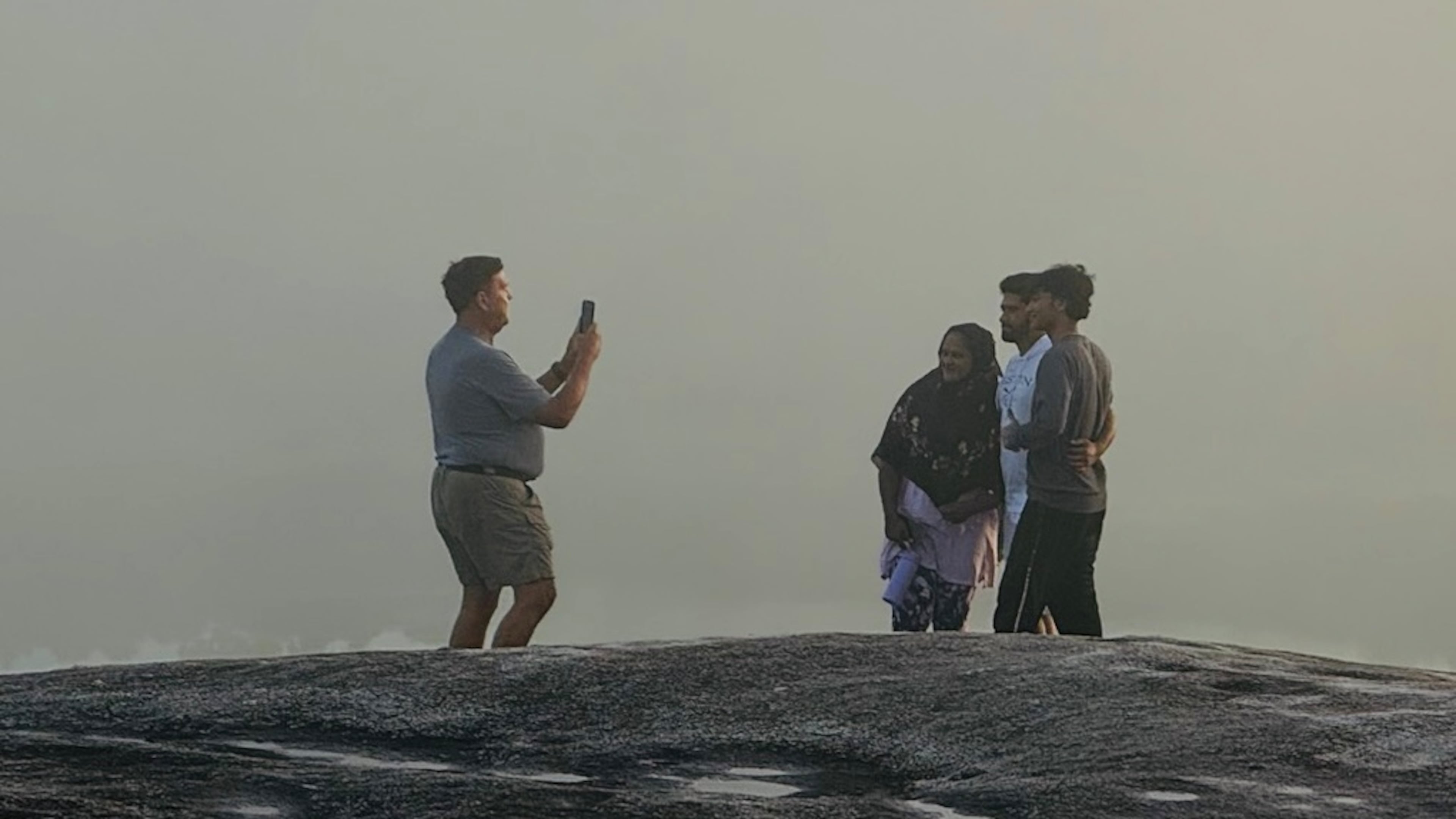 Emory Morsberger takes a photo of a family visiting Stone Mountain at sunrise. He has committed this random act of kindness 3,000 times. (Courtesy Emory Morsberger)