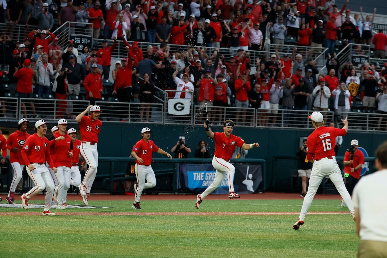 Georgia players rushed to celebrate with pitcher Zach Brown (right) after the team defeated Liberty 6-1 in an NCAA Regional final at Foley Field on Sunday, May 31, 2026, in Athens. (Miguel Martinez/AJC)
