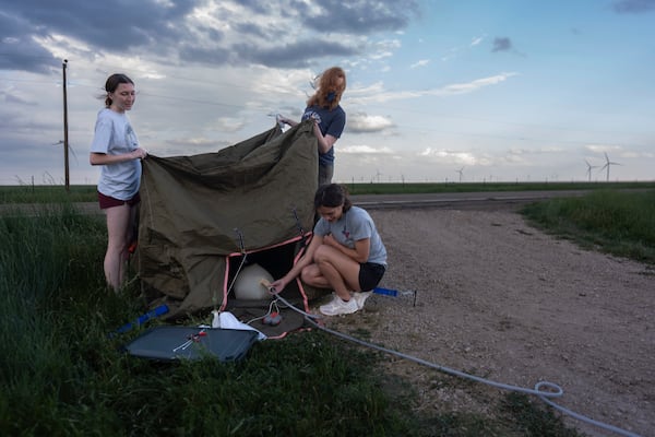 Project ICECHIP members from Northern Illinois University on the black team including Evelynn Mantia, left, and Olivena Carlisle, lower right, inflate a weather balloon with a radiosonde attached to collect data Wednesday, June 4, 2025, in Tucumcari, N.M. (AP Photo/Carolyn Kaster)