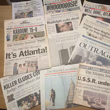 Copies of notable Atlanta Journal-Constitution headlines have been saved in columnist Bill Torpy’s basement. The newspaper is taking a new direction by becoming an all-digital news outlet. (Bill Torpy/AJC)