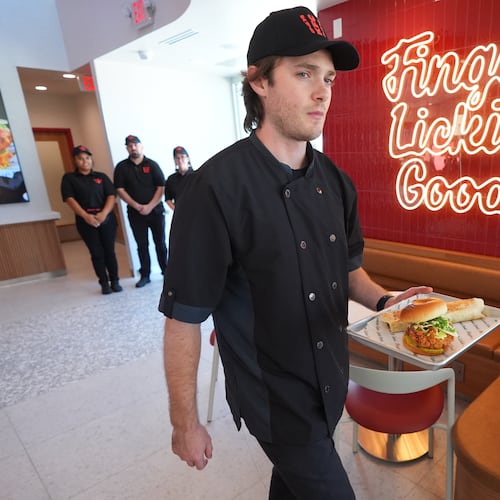 Jacob Mitchell carries a tray of food at new KFC restaurant pre-opening presentation in McKinney, Texas, Tuesday, Sept. 22, 2026. (AP Photo/LM Otero)