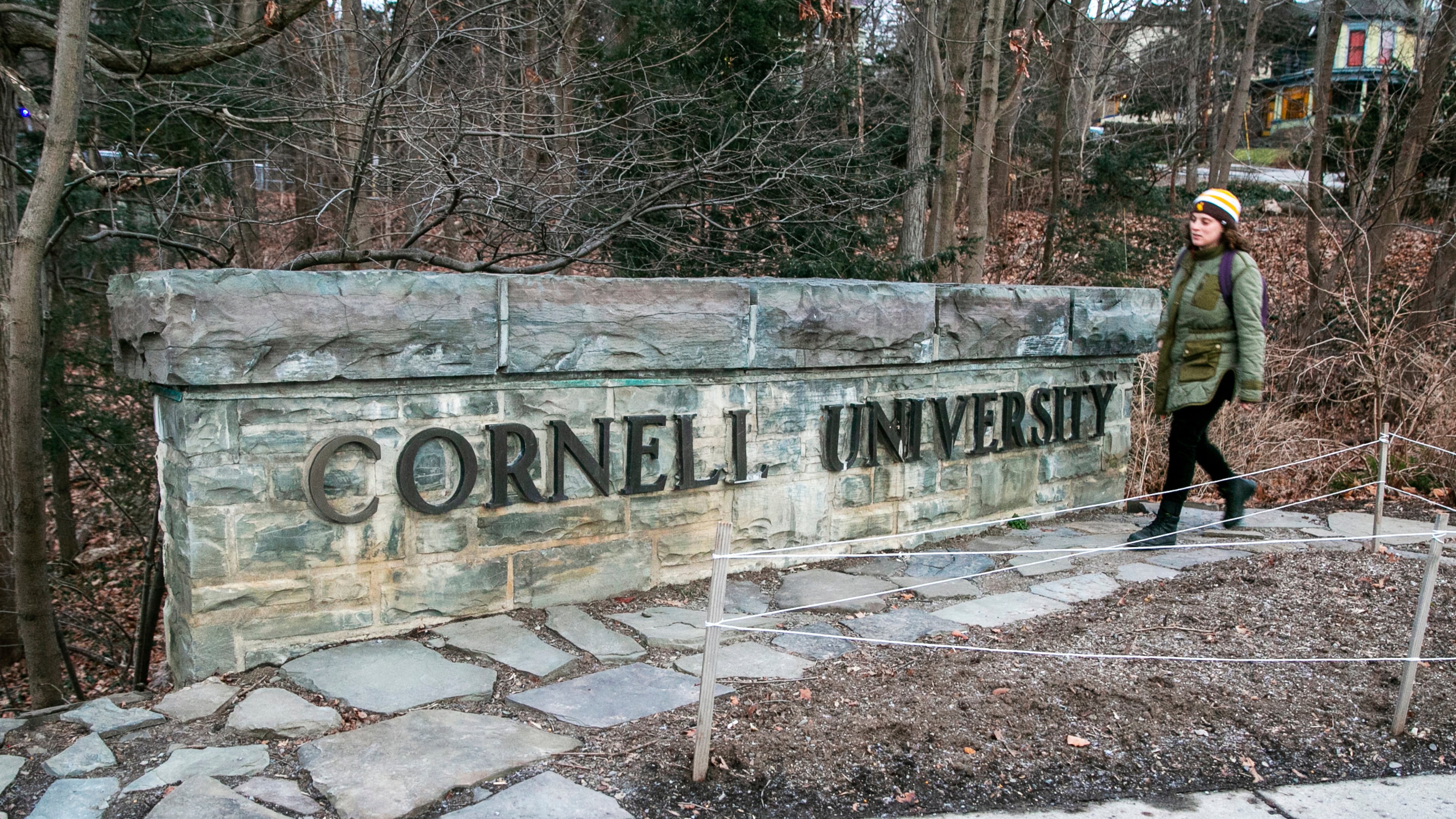 FILE - A woman walks by a Cornell University sign on the Ivy League school's campus in Ithaca, New York, Jan. 14, 2022. (AP Photo/Ted Shaffrey, File)