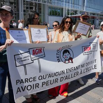 Members and supporters of the #METooEcole (#METooSchool) movement stage a protest to draw attention to a child abuse scandal in France in front of the courthouse in Paris on Tuesday May 26, 2026. The banner reads, in French, "Because no child should ever be afraid to go to school." (AP Photo/Michel Euler)