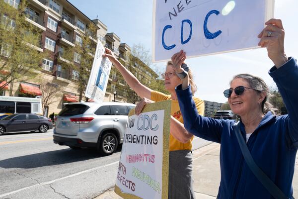 Chris Van Beneden, left, who worked at the Centers for Disease Control and Prevention for 25 years, and Julie Edelson, who worked there for 10, protest in support of the CDC in front of its Atlanta headquarters on Tuesday, April 1, 2025 after layoffs were announced. (AP Photo/Ben Gray)