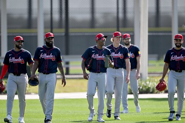 Braves closer Raisel Iglesias (center) and other pitchers walk onto the spring training practice field at CoolToday Park in Venice, Fla.