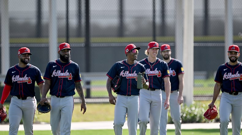Atlanta Braves pitcher Raisel Iglesias (center) and other players react as they walk on practice field during spring training workouts at CoolToday Park, Thursday, February 13, 2025, North Port, Florida. (Hyosub Shin / AJC)
