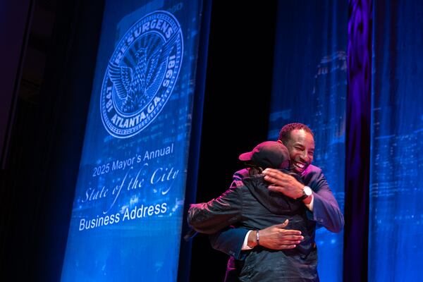 Mayor Andre Dickens hugs rapper Jermaine Dupri before giving the final State of the City address of his first term at the Woodruff Arts Center in Atlanta on Tuesday, Feb. 25, 2025. (Arvin Temkar/AJC)