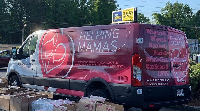 Packages of diapers in front of the Helping Mamas mobile van. Helping Mamas uses the van to transport baby supplies to the metro Atlanta community by hosting pickup events at churches, schools and other public locations. (Jamie Lackey)