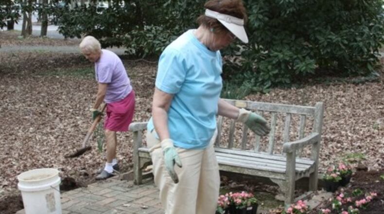 Roswell Garden Club members Carolyn Herndon (l) and Hilary Boyle work in pink garden at Smith Plantation. Credit: D. Vann.