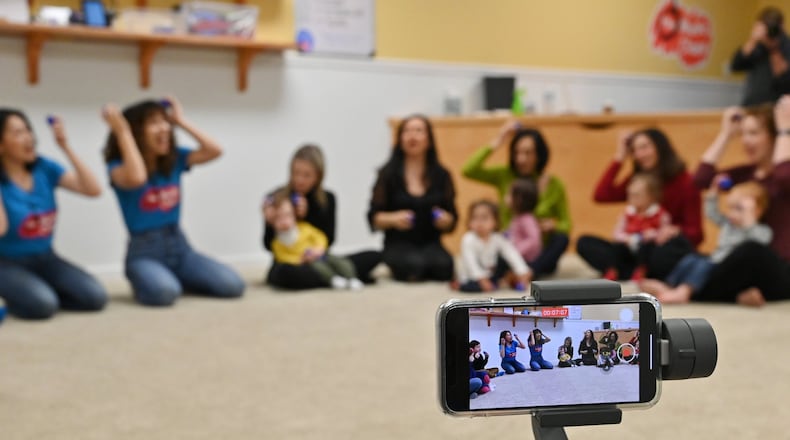 Rob Sayer, founder and CEO of The Music Class, holds a smartphone to film a class, which will broadcast in China for families who stuck at home during the coronavirus outbreak. The Music Class is an international music education program. (Hyosub Shin / Hyosub.Shin@ajc.com)